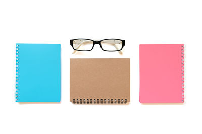 High angle view of eyeglasses on book against white background