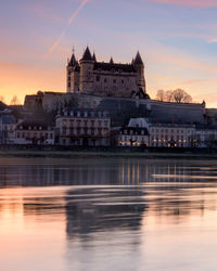 Reflection of buildings in city at sunset