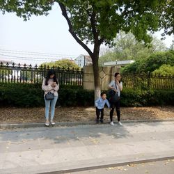 Full length of young woman with text on tree