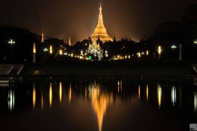 Reflection of illuminated shwedagon pagoda on pond