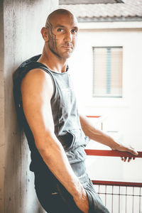 Muscular man leaning on wall in parking lot