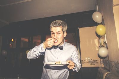 Portrait of hungry man eating from plate