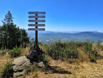 Information sign on volcano rim against clear sky