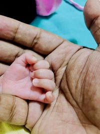 Midsection of mother holding baby hand