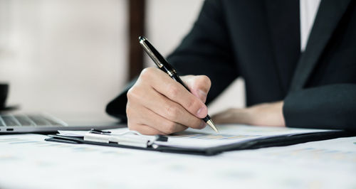 Midsection of businessman working at table