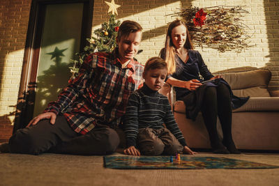 Portrait of siblings sitting on sofa at home