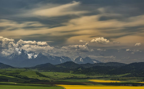 Scenic view of field and mountains against sky