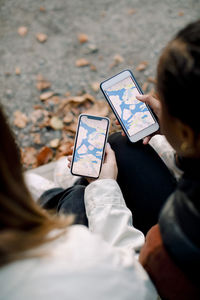 High angle view of teenage girls searching for friends through app on smart phones