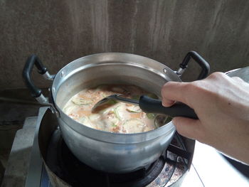 Midsection of person preparing food in kitchen