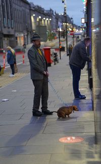 People with dog on street in city