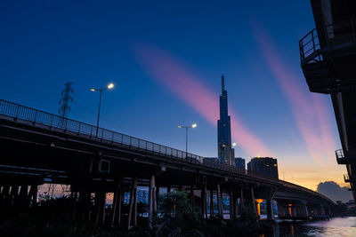 Low angle view of illuminated bridge against sky at sunset