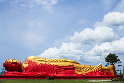 Low angle view of yellow temple against sky