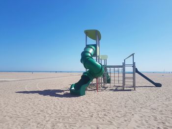 Boy on beach against clear blue sky