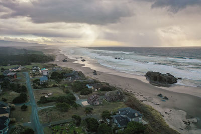 Coastal homes and vacation rentals in bandon, oregon coast with storm clouds in sky.