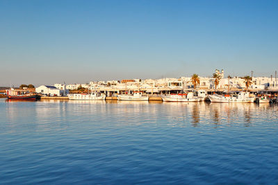 Sailboats in sea against buildings in city