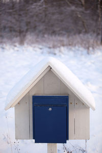 Close-up of birdhouse on snow covered land