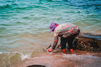 Side view of woman fishing in sea