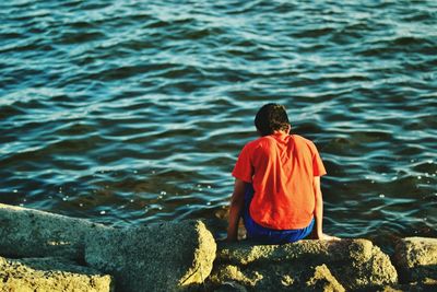 Rear view of man standing in water