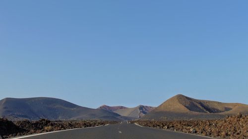 Scenic view of desert against clear blue sky