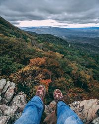 Low section of person on mountain against sky