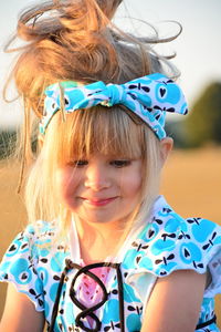 Close-up of girl wearing blue bandana while looking down