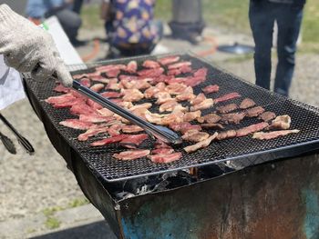 Midsection of man preparing food on barbecue grill