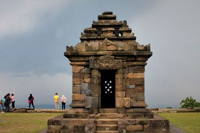 People at temple against sky