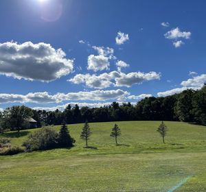 Scenic view of golf course against sky