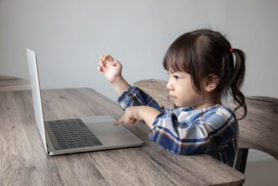 Full length of boy looking through mobile phone on table