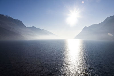 Scenic view of sea against bright sun