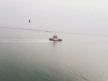 Boat sailing on sea against sky