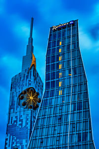 Low angle view of modern building against blue sky