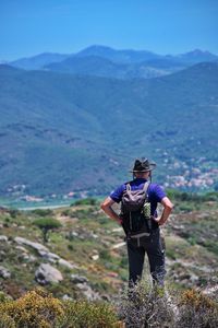 Rear view of senior man with backpack hiking