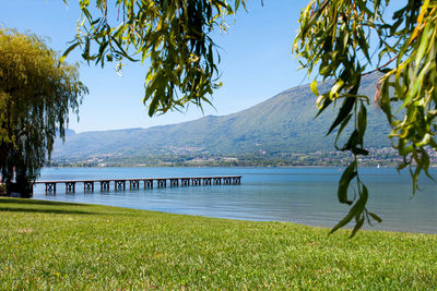 Scenic view of lake and mountains against blue sky