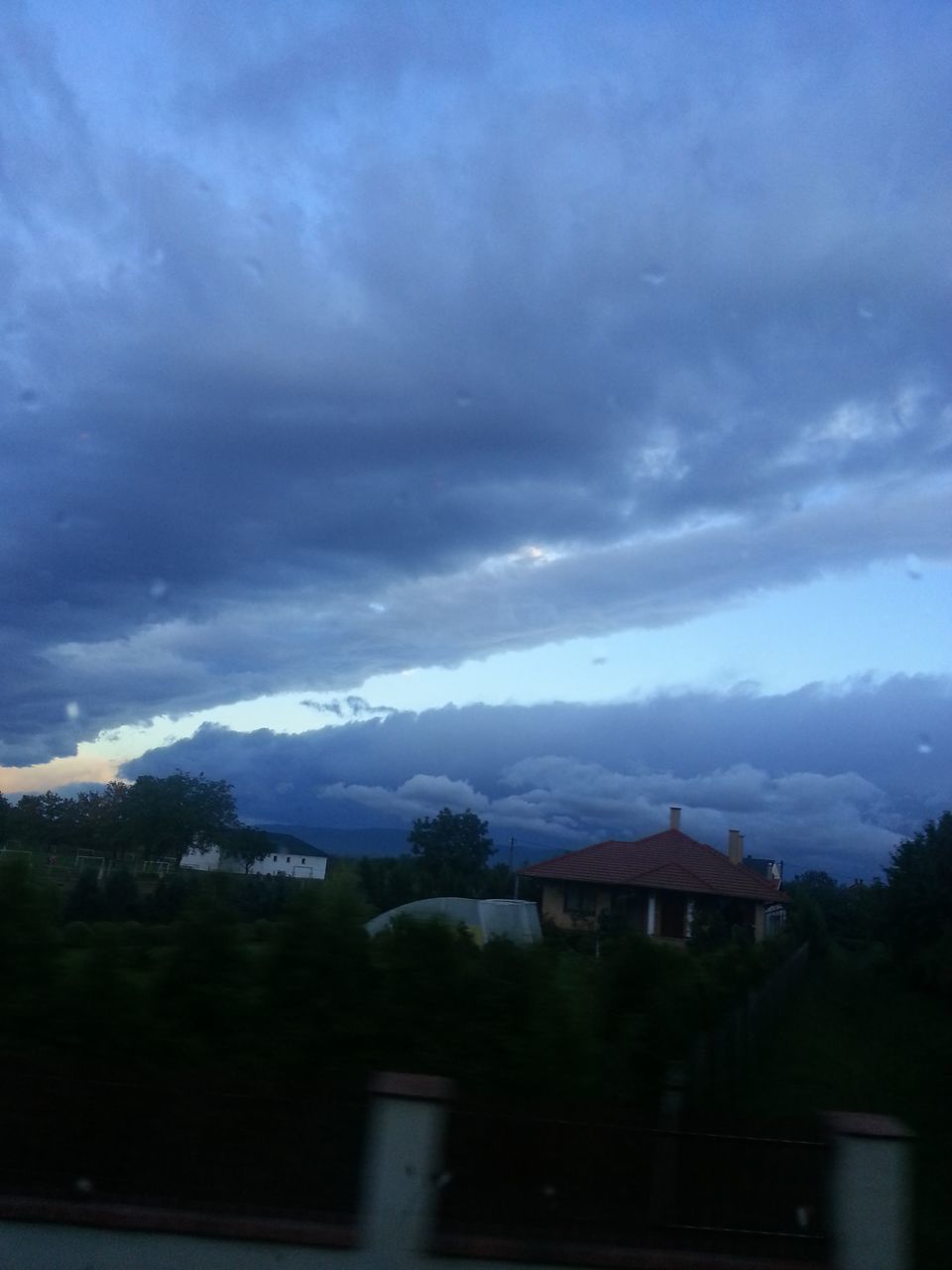 HOUSES AGAINST TREES AND MOUNTAINS AGAINST SKY