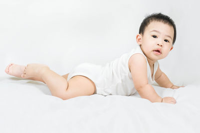 Portrait of young woman lying on bed at home