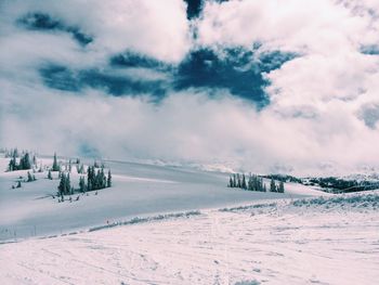 Scenic view of snow covered landscape against cloudy sky