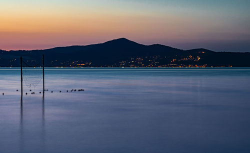 Scenic view of lake against sky at sunset