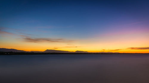 Scenic view of lake against romantic sky at sunset