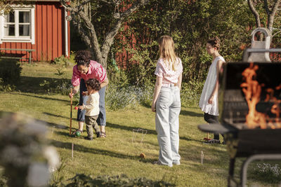 Family in garden playing croquet