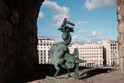 Statue of old building against cloudy sky