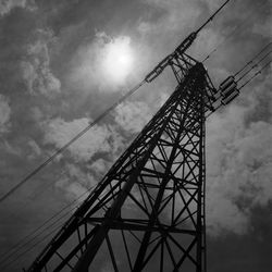 Low angle view of crane at construction site against sky