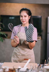 Portrait of young woman using mobile phone at table