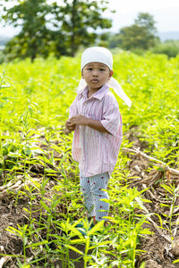 Portrait of smiling boy standing on field