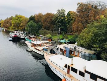 Boats moored by lake against sky