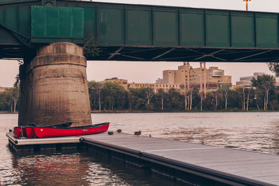 Bridge over river in city against sky