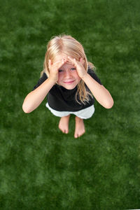 High angle view of young woman sitting on grassy field