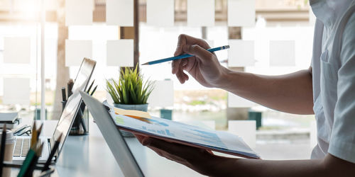 Midsection of woman working on paper