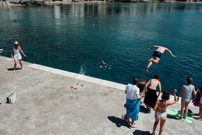 High angle view of people jumping in sea