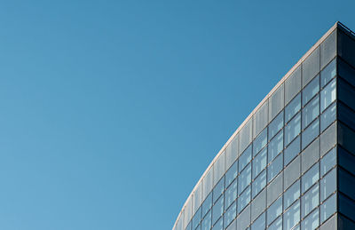 Low angle view of modern building against clear blue sky